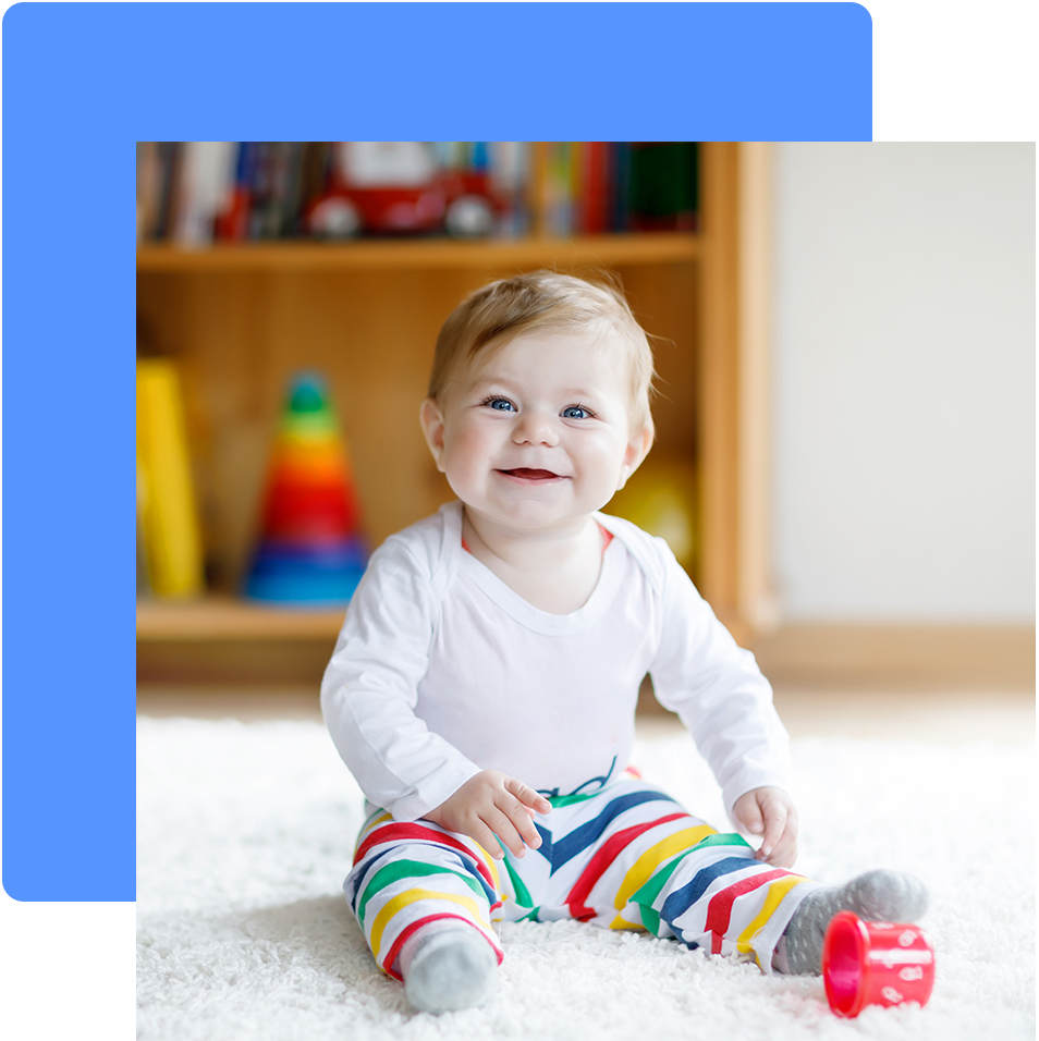 a baby is sitting on the floor and smiling